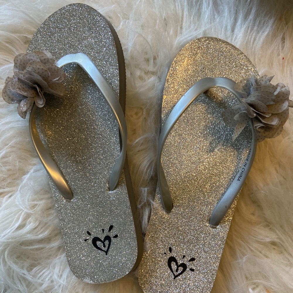 Flip flops with a flower on the toe strip